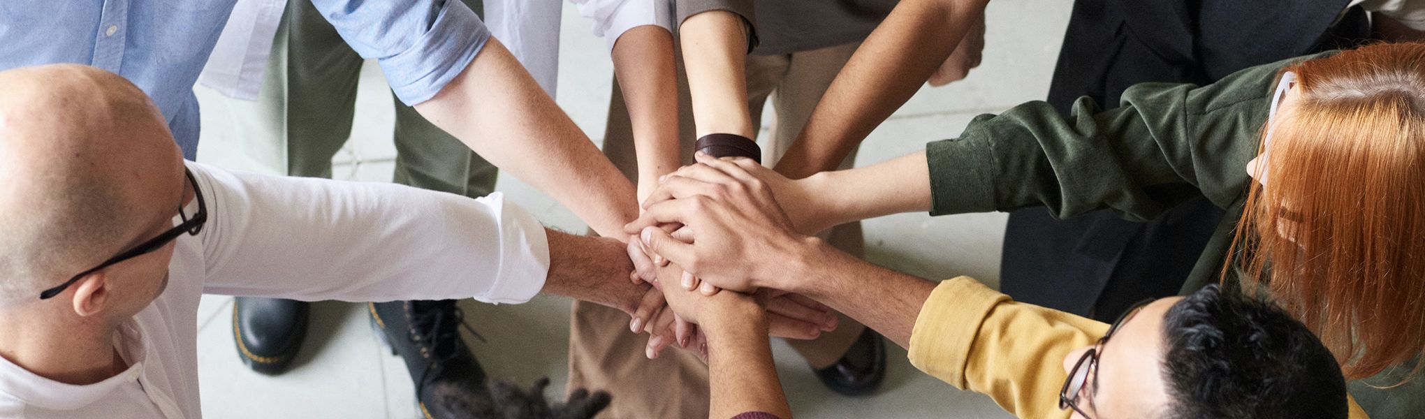 Se representa la comunidad educativa por unas manos unidas