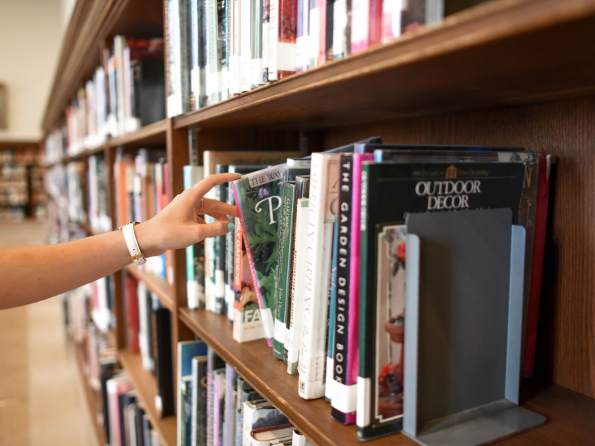 mano sacando un libro de la estantería