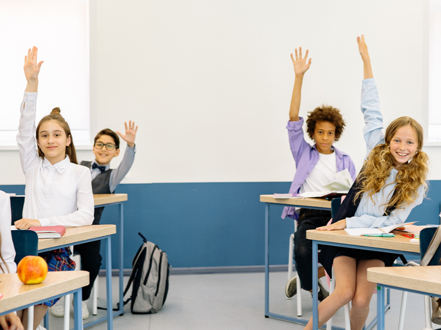 estudiantes levantando la mano en clase