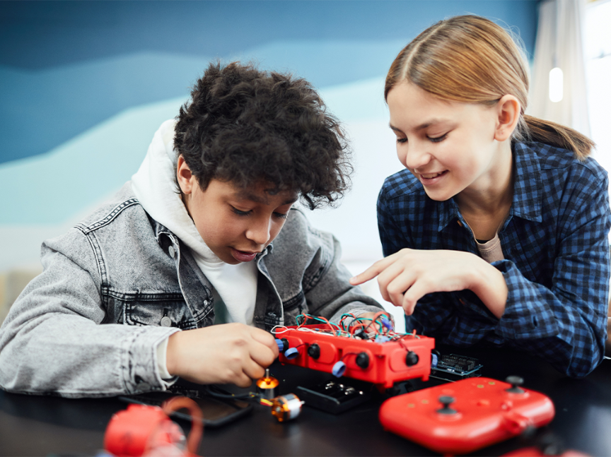 dos estudiantes experimentando con un robot