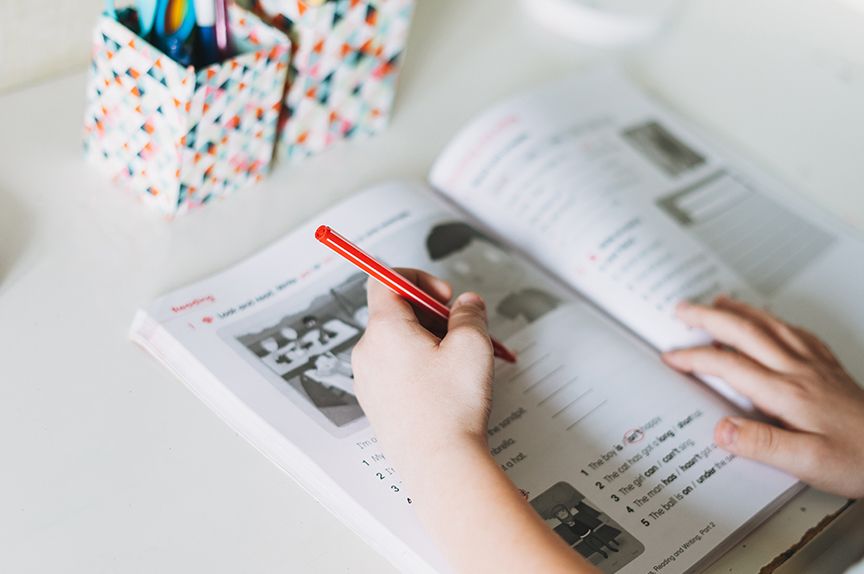 mano escribiendo en un libro de idiomas